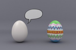 Two eggs in studio setting with speech bubble. One egg is blank and the other one is painted.